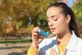 Young woman using asthma inhaler outdoors Royalty Free Stock Photo