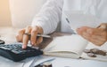 Young woman using calculator calculating monthly home expenses, taxes, bank account balance and credit card bills payment. Royalty Free Stock Photo