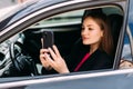 Young woman using cellphone to take photo inside a car Royalty Free Stock Photo