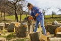 Young Woman using chainsaw to cut a log