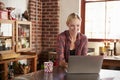 Young woman using computer in kitchen, close up front view Royalty Free Stock Photo