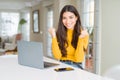 Young woman using computer laptop celebrating surprised and amazed for success with arms raised and open eyes Royalty Free Stock Photo