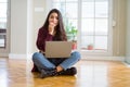 Young woman using computer laptop sitting on the floor looking stressed and nervous with hands on mouth biting nails Royalty Free Stock Photo