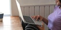 A young woman is using a computer laptop while sitting at the wooden working table Royalty Free Stock Photo