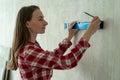 Young woman using construction level. A woman is engaged in repairs in the home Royalty Free Stock Photo