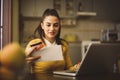 Young woman using credit card and checking bills.