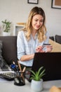 A young woman using a credit card at home to make a purchase or payment over the internet Royalty Free Stock Photo