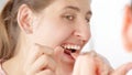 Young woman using dental floss to clean stuck food out of her teeth. Concept of teeth health, self checking mouth and oral hygiene Royalty Free Stock Photo