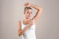 Young woman using deodorant on color background Royalty Free Stock Photo