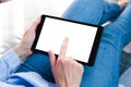 Young woman using digital tablet siting on the bed at home. Tablet blank screen mockup. Close-up. Place for text Royalty Free Stock Photo