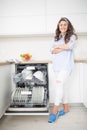 Young woman using a dishwasher in her modern kitchen Royalty Free Stock Photo