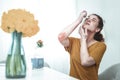 Young woman using eye drops while having allergy to flowers