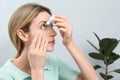 Young woman using eye drops at home Royalty Free Stock Photo