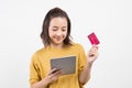 Young woman using her digital tablet and credit card to bring joy to the world Royalty Free Stock Photo