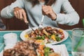 Young woman using knife and fork to cutting meat