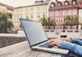 Young woman using laptop at cafe outdoors. Young beautiful girl working on computer in a city Royalty Free Stock Photo