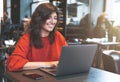 Young woman using laptop in a cafe - remote working concept Royalty Free Stock Photo