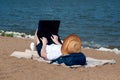 Young woman using laptop computer on a beach. Freelance work concept Royalty Free Stock Photo