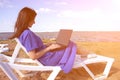 Young woman using laptop computer on a beach. Freelance work concept Royalty Free Stock Photo