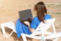 Young woman using laptop computer on a beach. Freelance work concept Royalty Free Stock Photo