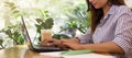 Young woman using laptop computer in cafe and drinking coffee Royalty Free Stock Photo