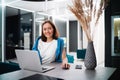 Young woman using laptop computer at kitchen. Portrait of business woman working on notebook at home kitchen. Casual Royalty Free Stock Photo