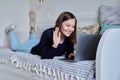 Young woman using laptop lying on sofa at home Royalty Free Stock Photo