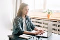 Young woman using laptop computer in a modern office setting and student girl working from the comfort of home. Online Royalty Free Stock Photo