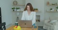 Young woman using laptop computer. Portrait of business woman watching news at laptop screen and drinking coffee at home Royalty Free Stock Photo