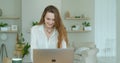 Young woman using laptop computer. Portrait of business woman watching news at laptop screen and drinking coffee at home Royalty Free Stock Photo