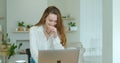 Young woman using laptop computer. Portrait of business woman watching news at laptop screen and drinking coffee at home Royalty Free Stock Photo