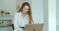 Young woman using laptop computer. Portrait of business woman watching news at laptop screen and drinking coffee at home Royalty Free Stock Photo