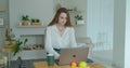 Young woman using laptop computer. Portrait of business woman watching news at laptop screen and drinking coffee at home Royalty Free Stock Photo