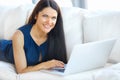 Young Woman Using a Laptop Computer While Relaxing at Home Royalty Free Stock Photo