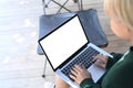 Young woman using laptop computer and sitting in folding chair near camp tent.