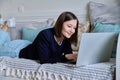 Young woman using laptop lying on sofa at home Royalty Free Stock Photo