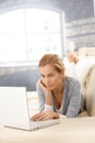 Young woman using laptop on couch Royalty Free Stock Photo