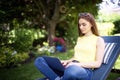 Young woman using laptop in the garden while working from home Royalty Free Stock Photo