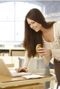 Young woman using laptop having croissant Royalty Free Stock Photo