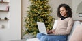 Young woman using laptop at home during Christmas holiday