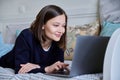 Young woman using laptop lying on sofa at home Royalty Free Stock Photo