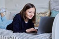 Young woman using laptop lying on sofa at home Royalty Free Stock Photo