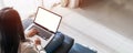 Young woman using laptop and relaxing on sofa in living room at cozy home Royalty Free Stock Photo