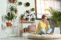Young woman using laptop in room with home plants Royalty Free Stock Photo