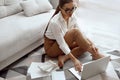 Young woman using laptop, sitting on floor, beautiful girl shopping or chatting online in social network Royalty Free Stock Photo