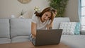 Young woman using laptop sitting on sofa at home Royalty Free Stock Photo