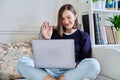 Young woman using laptop sitting on sofa at home Royalty Free Stock Photo