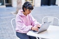 Young woman using laptop sitting on table at coffee shop terrace Royalty Free Stock Photo