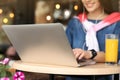 Young woman using laptop at table in cafe Royalty Free Stock Photo