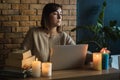 Young woman using laptop to work at home during electricity outage. Remote work at home concept. Freelancer working at the